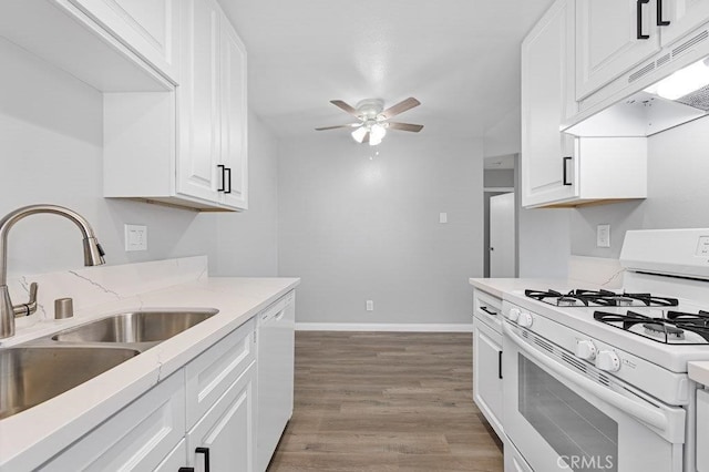 kitchen with white appliances, sink, ceiling fan, light hardwood / wood-style floors, and white cabinetry