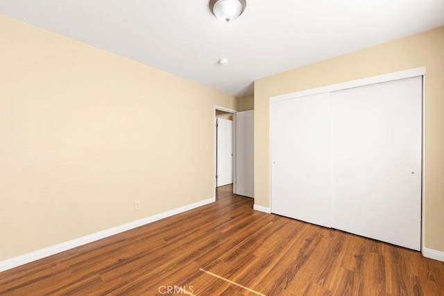 unfurnished bedroom featuring hardwood / wood-style flooring and a closet