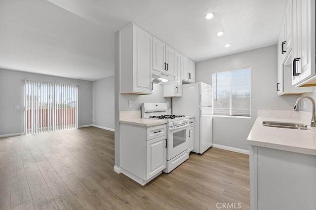 kitchen featuring white cabinetry, a sink, light wood-type flooring, white appliances, and under cabinet range hood