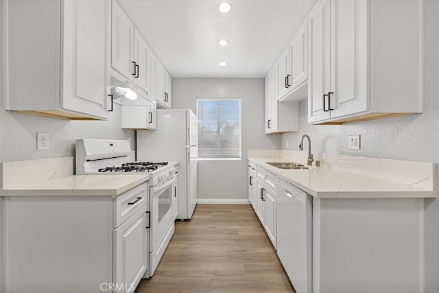 kitchen featuring white appliances, sink, light hardwood / wood-style floors, light stone counters, and white cabinetry