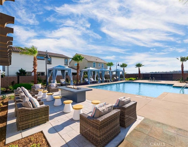 view of pool featuring a gazebo, an outdoor living space with a fire pit, and a patio area