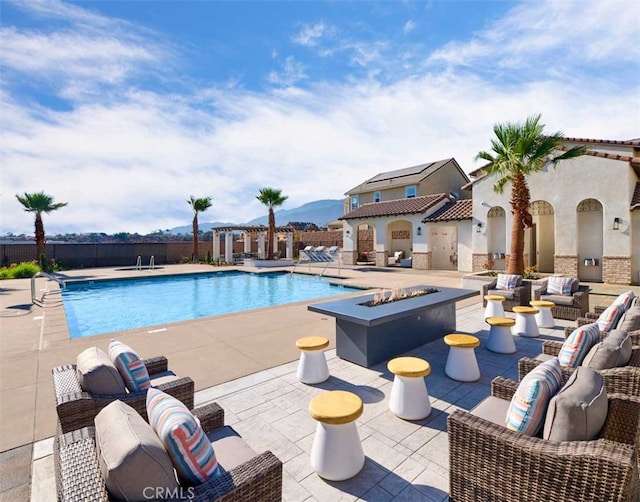 view of swimming pool with a patio area and an outdoor living space with a fire pit