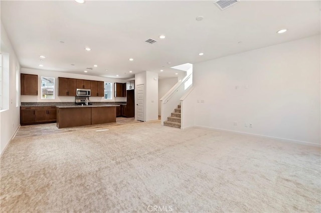 unfurnished living room featuring light colored carpet