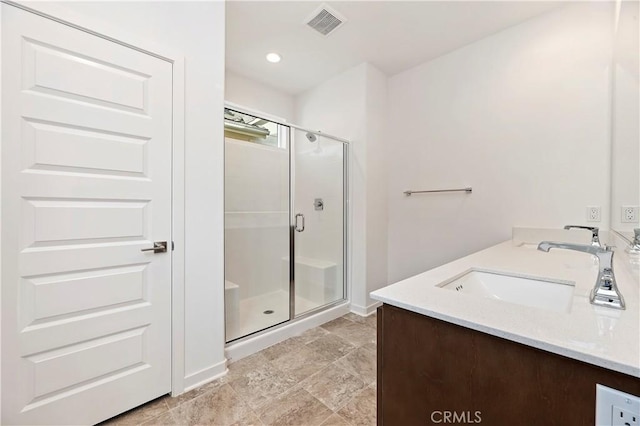 bathroom with a shower with shower door and vanity