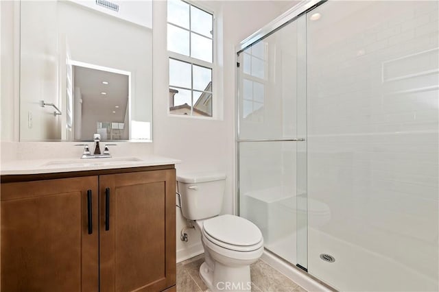 bathroom featuring toilet, vanity, tile patterned floors, and walk in shower