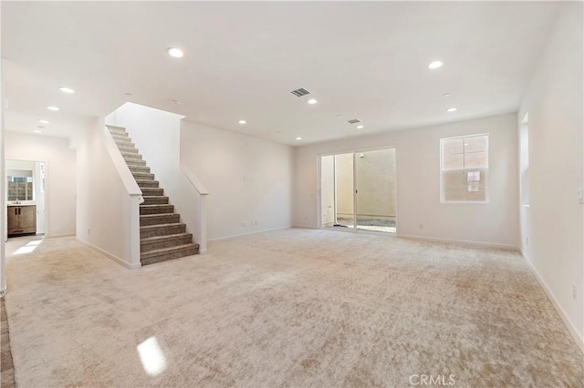 unfurnished living room featuring light carpet