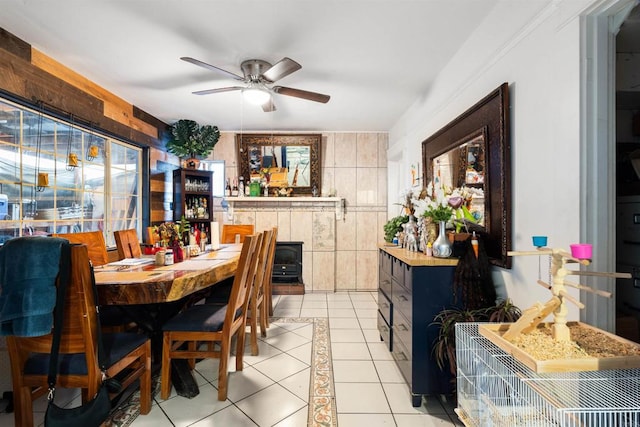 tiled dining area featuring ceiling fan and tile walls