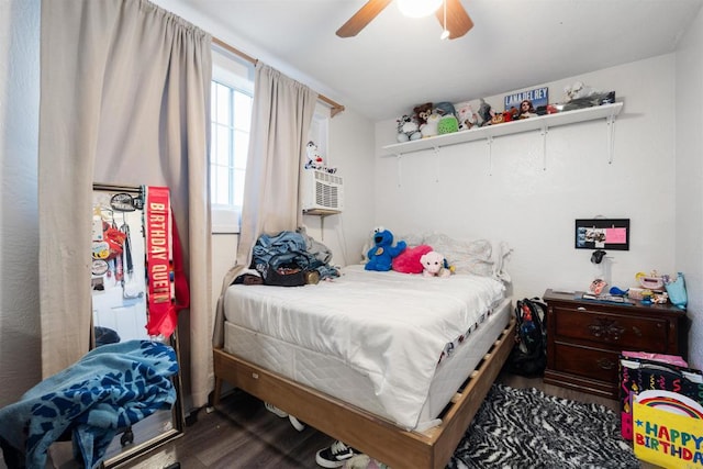 bedroom with ceiling fan, cooling unit, and dark wood-type flooring