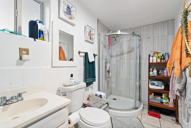 bathroom featuring tile walls, tile patterned flooring, walk in shower, vanity, and toilet