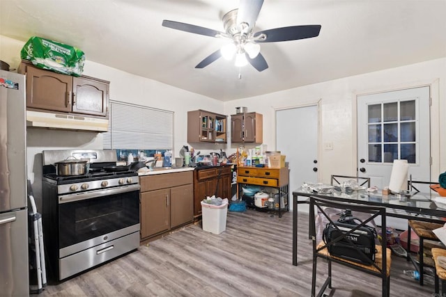 kitchen featuring light wood-type flooring, ceiling fan, appliances with stainless steel finishes, and dark brown cabinetry