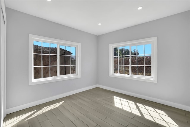 empty room with a healthy amount of sunlight and hardwood / wood-style flooring