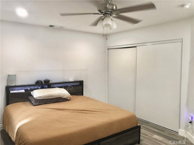 bedroom with ceiling fan, hardwood / wood-style flooring, and a closet