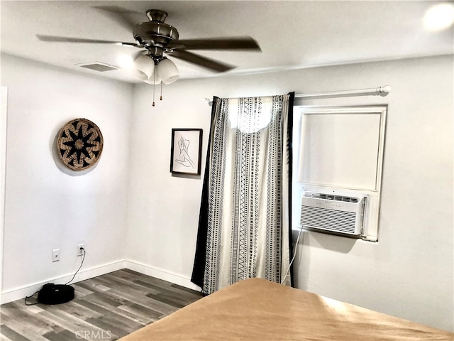 interior space with ceiling fan, cooling unit, and hardwood / wood-style floors