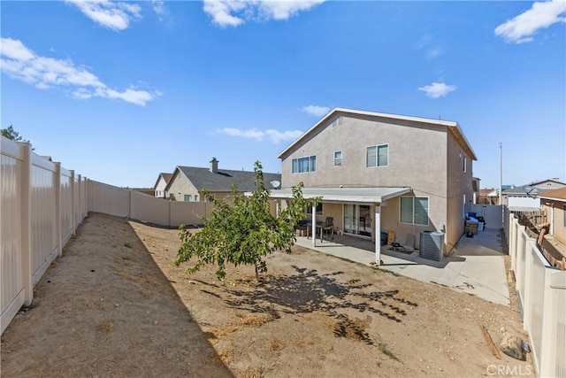 back of property with cooling unit and a patio