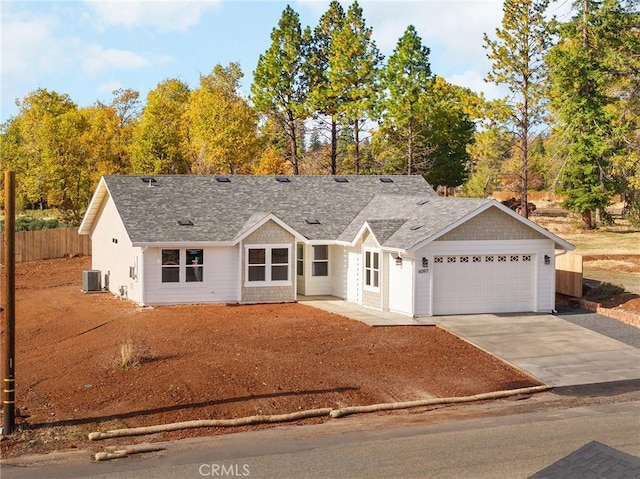 view of front of home with a garage and central air condition unit