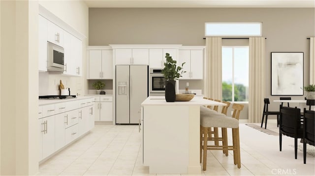 kitchen featuring a kitchen bar, appliances with stainless steel finishes, white cabinetry, and a kitchen island