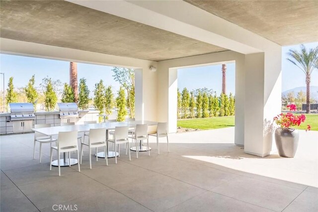 view of patio featuring a grill, a bar, and exterior kitchen