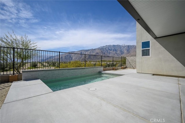 view of pool with a fenced backyard, a fenced in pool, a mountain view, and a patio