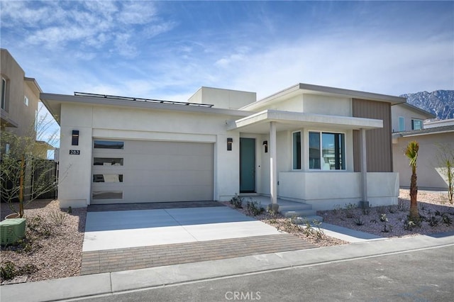 view of front of house featuring central air condition unit, decorative driveway, and a garage