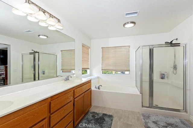 bathroom featuring shower with separate bathtub and vanity