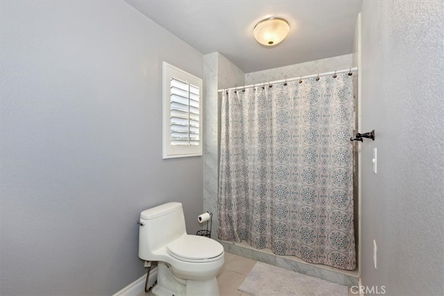 bathroom with tile patterned flooring, toilet, and curtained shower