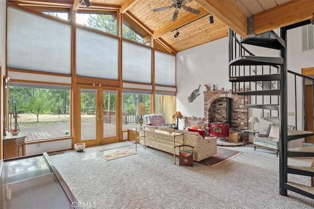 carpeted living room with beamed ceiling, ceiling fan, wooden ceiling, a wood stove, and high vaulted ceiling