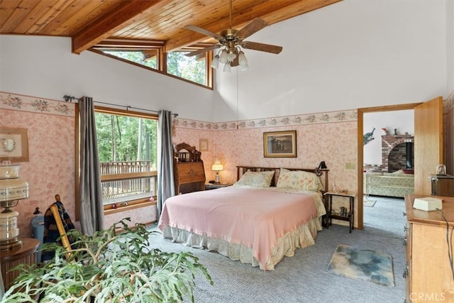 carpeted bedroom with high vaulted ceiling, beamed ceiling, ceiling fan, and wood ceiling