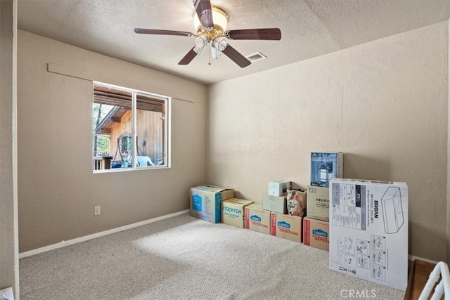 recreation room featuring carpet, a textured ceiling, and ceiling fan