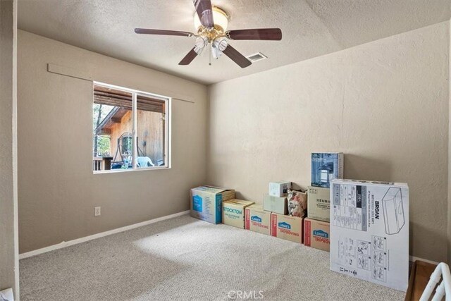 rec room with visible vents, carpet floors, a textured ceiling, and ceiling fan