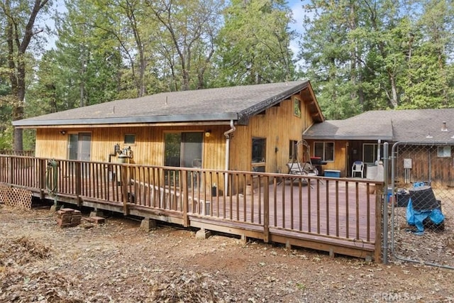 rear view of house featuring a deck and a shingled roof