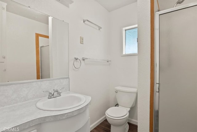 bathroom featuring toilet, walk in shower, vanity, and wood-type flooring