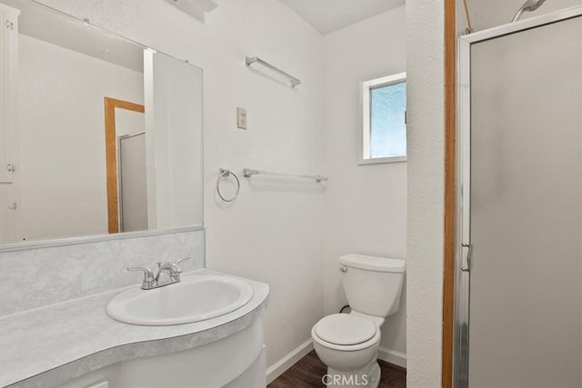 full bath featuring toilet, baseboards, wood finished floors, a shower stall, and vanity