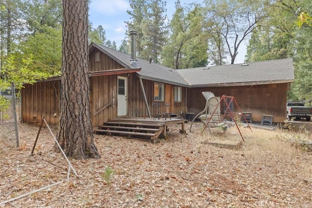 rear view of property with a shingled roof