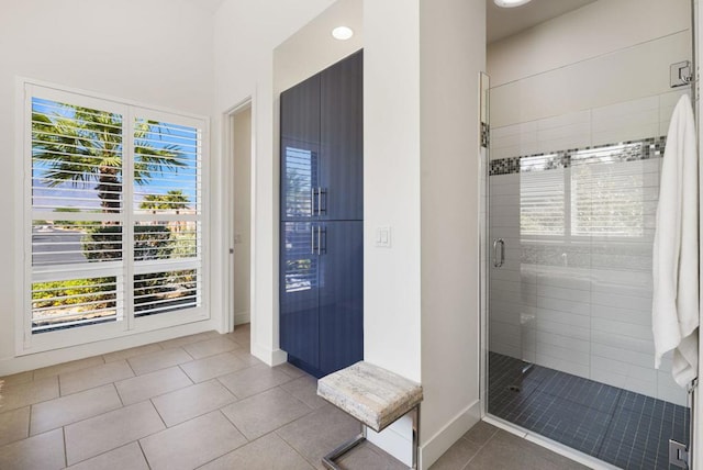 bathroom with tile patterned flooring, plenty of natural light, and a shower with door