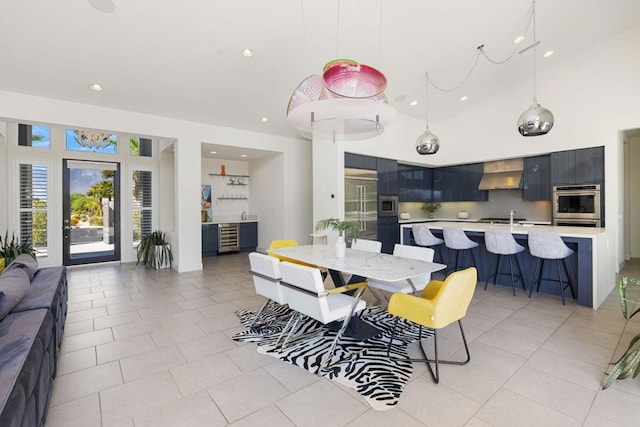 dining space featuring sink, high vaulted ceiling, and light tile patterned floors