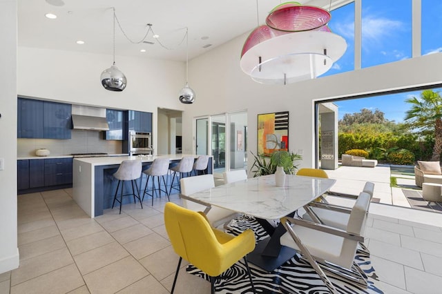 dining space featuring a high ceiling and light tile patterned floors