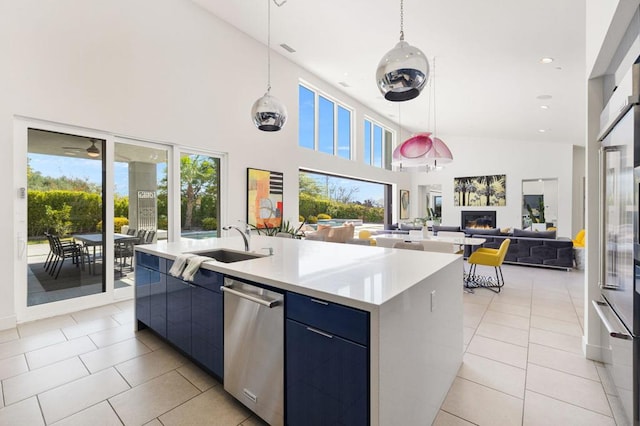 kitchen featuring high vaulted ceiling, hanging light fixtures, a kitchen island with sink, stainless steel dishwasher, and light tile patterned floors