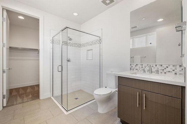 bathroom featuring tile patterned flooring, tasteful backsplash, vanity, an enclosed shower, and toilet