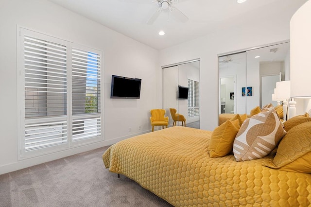 bedroom featuring carpet, two closets, and ceiling fan