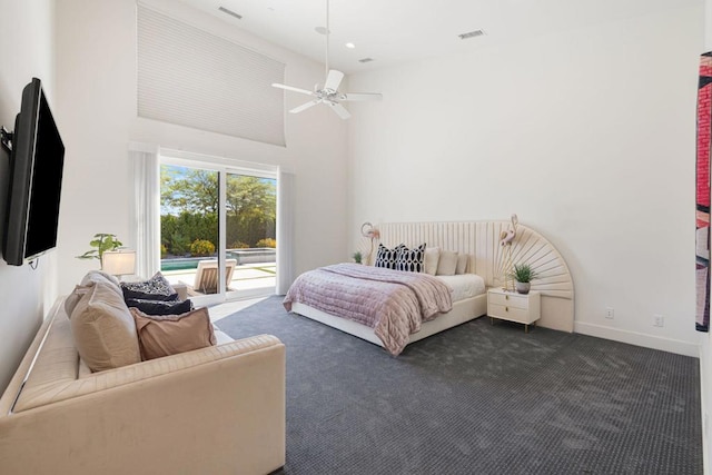 carpeted bedroom with access to exterior, ceiling fan, and a high ceiling