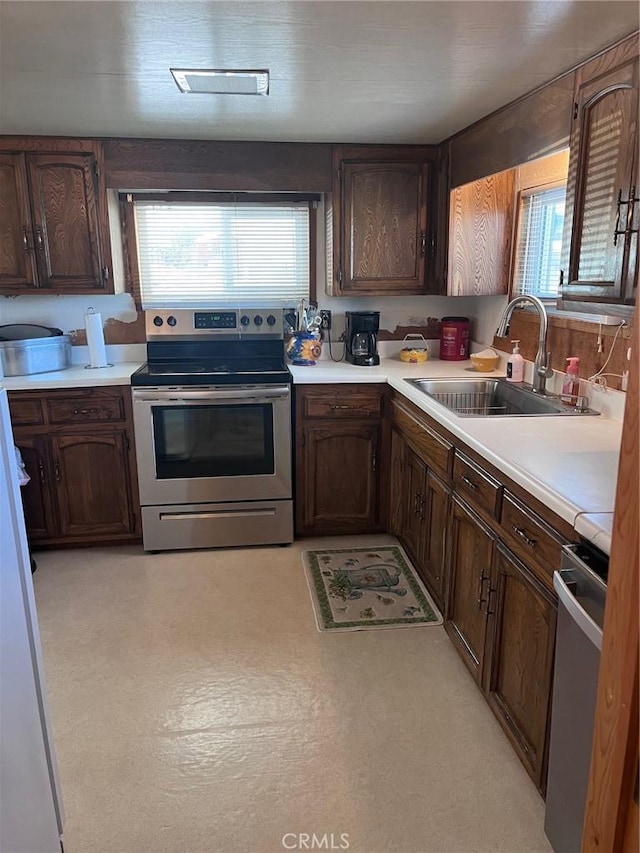 kitchen featuring stainless steel range, dark brown cabinetry, stainless steel electric stove, and sink