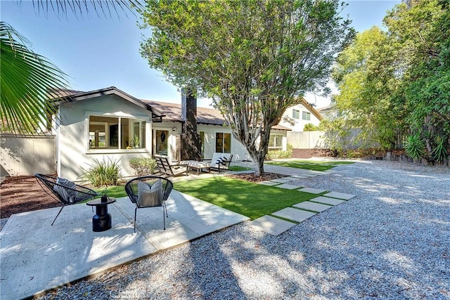 view of front of house with a front yard, an outdoor living space, and a patio