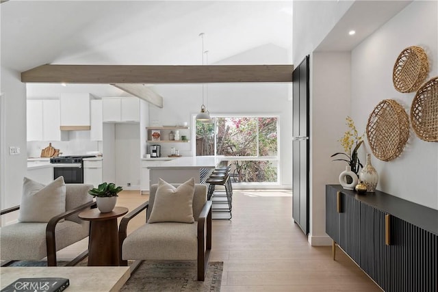 interior space featuring beam ceiling, high vaulted ceiling, and light hardwood / wood-style flooring