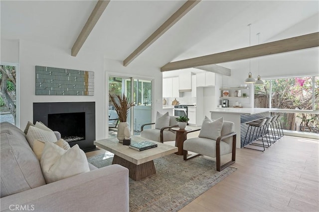 living room featuring beam ceiling, plenty of natural light, high vaulted ceiling, and light hardwood / wood-style floors