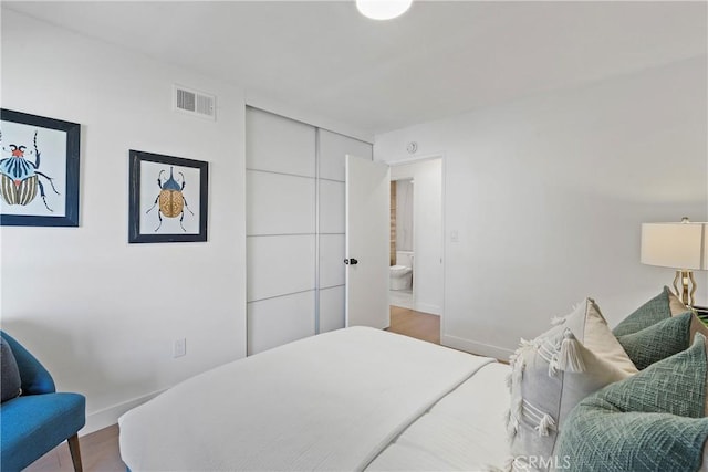 bedroom featuring connected bathroom and hardwood / wood-style floors