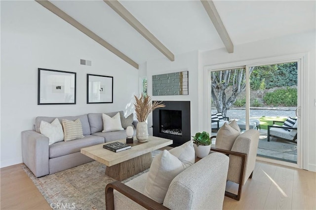 living room featuring beamed ceiling, light wood-type flooring, and high vaulted ceiling