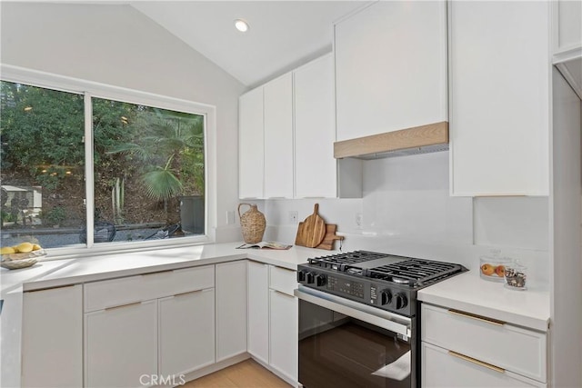 kitchen featuring white cabinets, light wood-type flooring, gas stove, and lofted ceiling