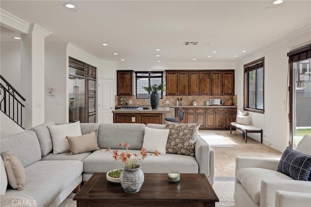 tiled living room with a wealth of natural light and crown molding