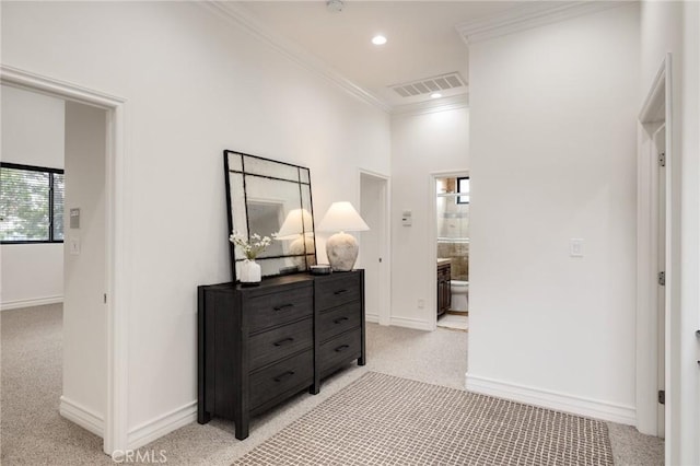 corridor featuring crown molding and light carpet