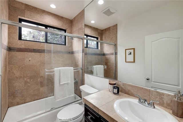 full bathroom with vanity, toilet, and enclosed tub / shower combo